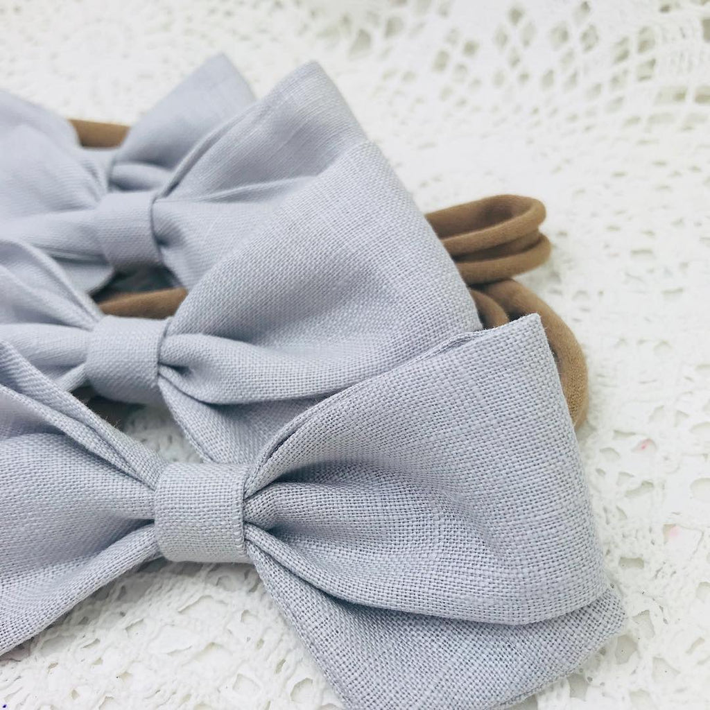 Blend Bow in Light Grey Linen. Secured to a soft nylon headband